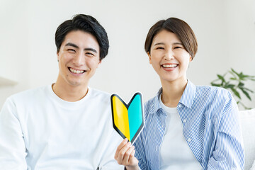カメラ目線の初心者マークを持つカップル