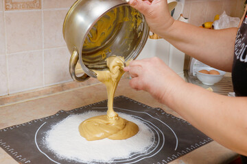 woman prepares dough by pouring ingredients into flour