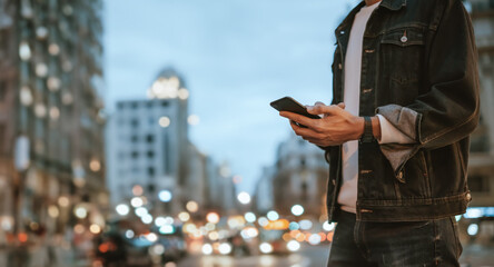 Close-up of male hands with smartphone outdoors