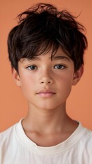 Close up Portrait of a asian boy wearing a brown shirt against an orange background