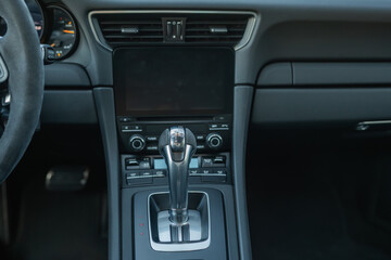 Fototapeta premium Center console of a luxury car featuring a sleek gear shifter and control buttons.
