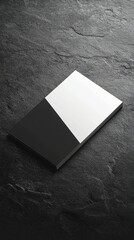 A modern business card mockup featuring metallic edges, displayed on a textured dark slate surface