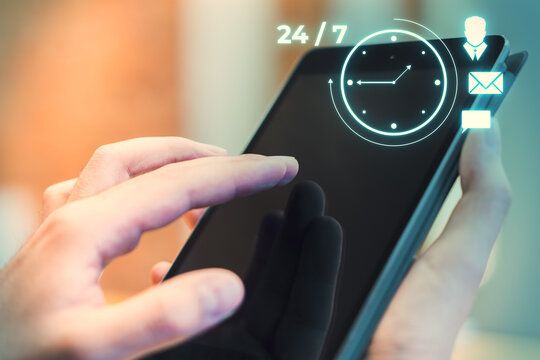 Person interacting with smartphone with 24 7 time management hologram icons on screen. Business and technology concept.