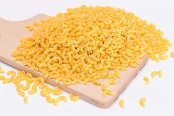 A Heap of Uncooked Chifferi Rigati Pasta on Wooden Kitchen Board. Fat and Unhealthy Food. Classic Dry Macaroni. Italian Culture and Cuisine. Raw Pasta
