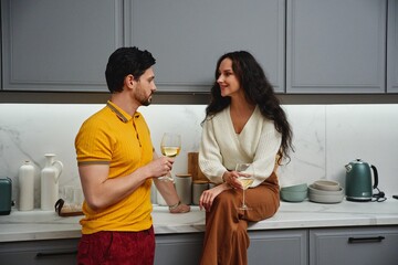 Charming couple enjoying drinks together in a modern kitchen setting