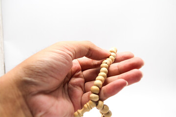 Fototapeta premium Male hand asian holding muslim beads rosery or tasbih for pray with isolated background.