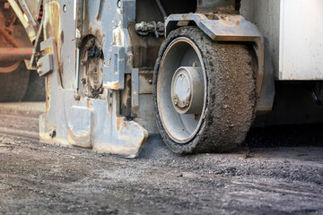 An asphalt milling machine grinds old pavement as part of road construction work in the city downtown © Vladimir Razgulyaev