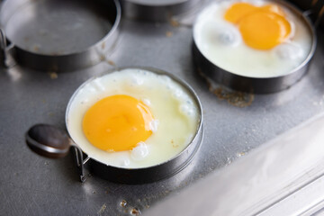 Two eggs are in a pan on a stove