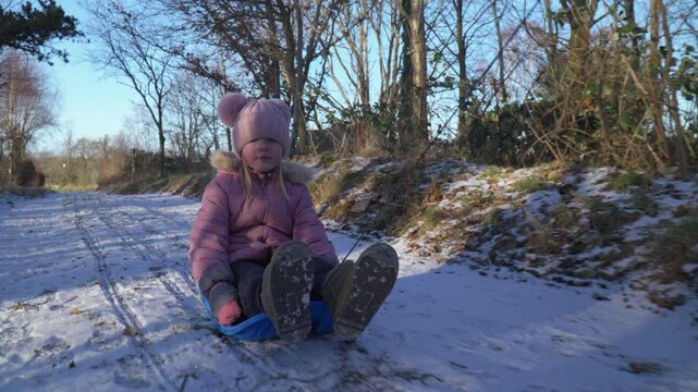 Girl being pulled on a bobsled