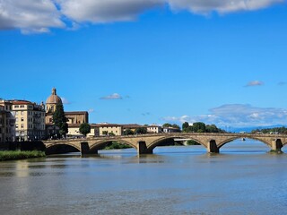 Obraz premium Florence, Italy - October 5, 2024: Discovering the city of Florence in autumn days. Frome the Duomo to Ponte Vecchio, old architecture covering the city. Beautiful sky reflected over Arno river.