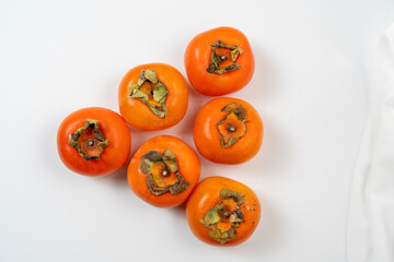 Persimmons are sweet, orange fruits commonly enjoyed in autumn
