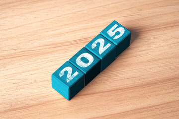 2025 on blue wooden block cube for preparation new year change and start new business target...