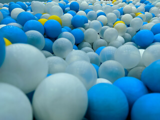 A close-up view of vibrant blue, white, and transparent glass balls captures a beautiful blend of colors and textures.