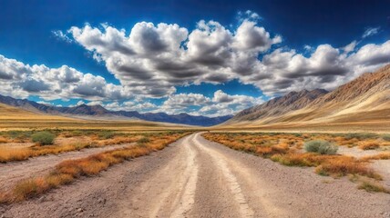 The Dusty Dirt Track Road. Highway in to the mountains, with blue skies and clouds. Ideal Desktop background or Wallpaper.