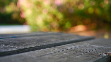 Wooden table in the park, blurred bright background, frontal view, for editing, bokeh, blurred area