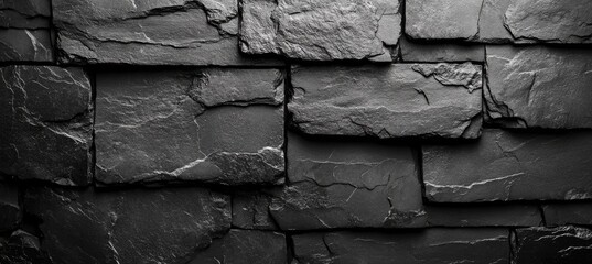 A textured surface of dark slate stones arranged in a pattern.