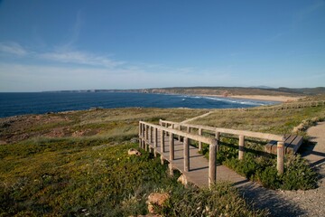 Scenic coastal view with a wooden boardwalk leading to a sandy beach in Algarve, Portugal