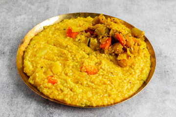 Khichdi is a comforting Indian dish made with rice, lentils, and mild spices, often served as a nourishing, easy-to-digest meal.