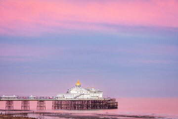 Obraz premium Lilac skies over Eastbourne Pier at low tide and sunset east Sussex south east England UK