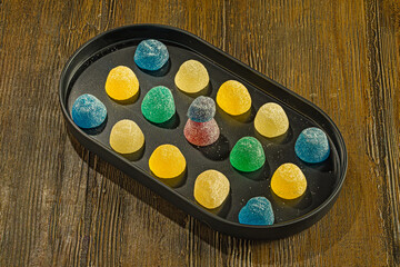Colorful gummy candies on a black tray