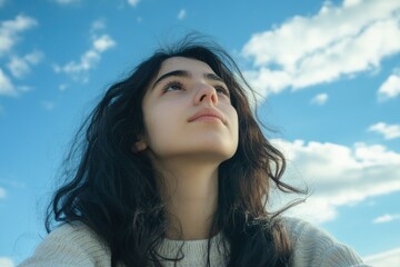 Fototapeta premium A person with long black hair gazing upwards, possibly lost in thought