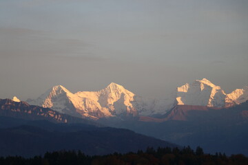 Famous Eiger, Monch and Jungfrau in special lighting conditions in autumn