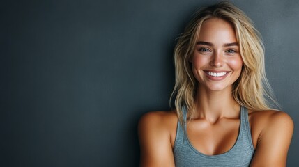 Fototapeta premium A young woman with a radiant smile poses confidently against a neutral backdrop, showcasing her enthusiasm and positivity during a bright, sunny day