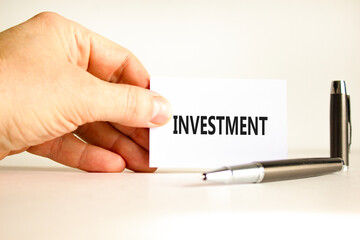 Investment symbol. Concept word Investment on beautiful white card. Beautiful wooden background. Businessman hand. Beautiful black pen. Business investment concept. Copy space.