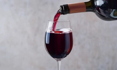 Sommelier pouring a deep red wine into a glass, enriching the tasting experience with its captivating aroma and complex bouquet