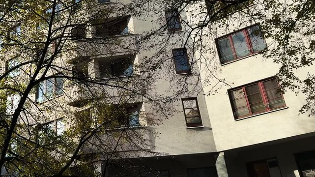 Old building with windows. Fasada budynku mieszkalnego za jesiennymi drzewami