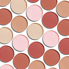 Swatches eyeshadow refills as minimal geometric pattern on white. Pastel matte pans brown beige nude shades with sun shadows, detailed texture, cosmetic, beauty concept makeup, top view layout