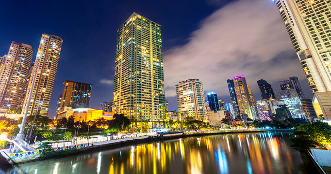 Modern city buildings along the Pasig River, at night in the Makati District,Manila,The Philippines.