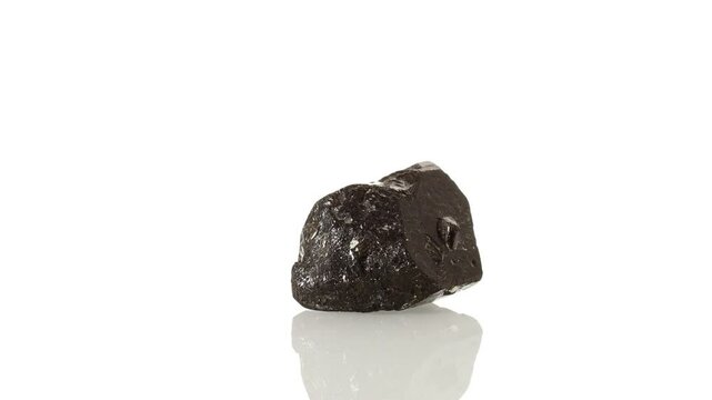 mineral stone Schorl rotates in a circle on a white background