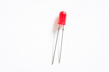 Macro shot of a small red coloured LED light, isolated against white background.