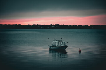 Naklejka premium boat in the bay at sunset