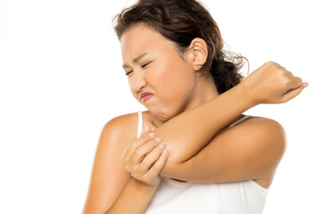 Fototapeta premium Asian woman with pain in the elbow, holding it with arm with painful expression on her face