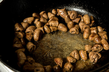 Close-up of golden fried chicken hearts in a skillet. Delicious and hearty dish, perfect for authentic homemade recipes.