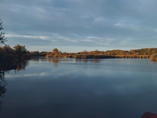 Obraz premium Autumn river shore landscape, calm panoramic view, blue and brown, water reflection
