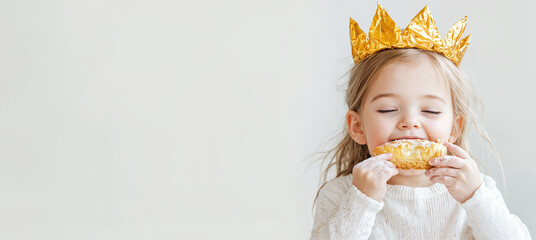 child wearing crown and eating slice of king cake