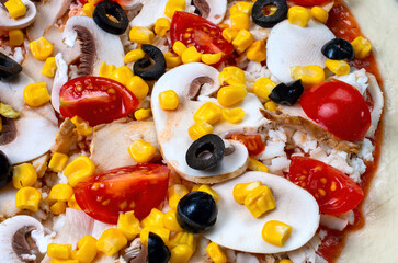 Raw pizza ingredients close-up, tomatoes, mushrooms, ham, corn, olives