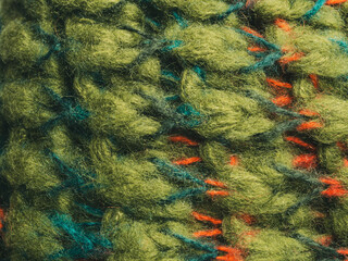 Close-up of a bright green knitted wool scarf. Detailed texture and rich color highlight the quality and comfort of this stylish