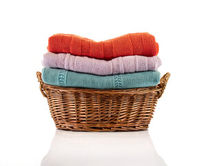 Obraz premium Stack of wool sweater Colorful Folded Knit Sweaters on White Background, wool sweater in wicker basket isolated. winter, knit wool sweater