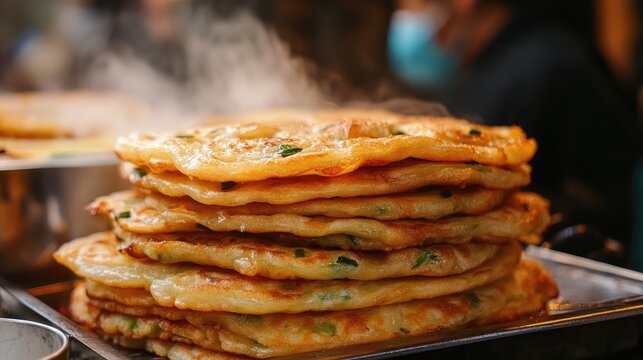 Close-up of fried Chinese scallion pancakes (laobing), served hot from a street food vendor, showcasing its golden, flaky layers.