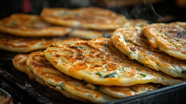 Close-up of fried Chinese scallion pancakes (laobing), served hot from a street food vendor, showcasing its golden, flaky layers.