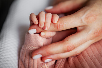 Close Up Newborn Baby Hand Touching Mother Finger Tenderly, Heartwarming Moment of Connection and Love Between Mom and Child