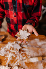 Cooking Christmas cookies with family. Children daughter hands top view on making gingerbread biscuits with cookie cutters, with New Year Christmas decoration