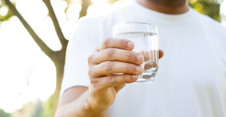 hand holding glass of water in outdoor