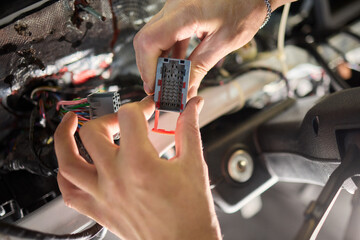 Skilled Hands Connecting Various Electrical Connectors in Automotive Repair Services and Maintenance