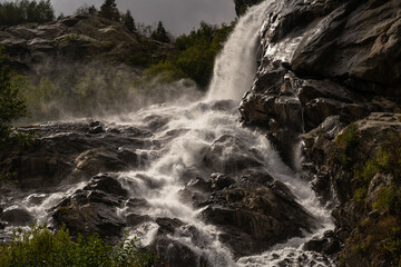 View of the Alibek Waterfall, formed as a result of the fall of the Yalovchatka River from the Alibeck Glacier, Dombay, Karachai-Cherkessia, Russia. High quality photo