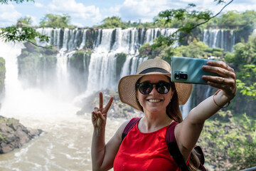 Mujer turista disfrutando de su recorrido por las cataratas del Iguazú, en el Parque Nacional...